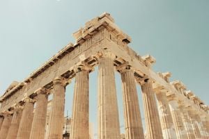 Panoramic view of the majestic Acropolis in Athens at sunset, with the city lights twinkling below.