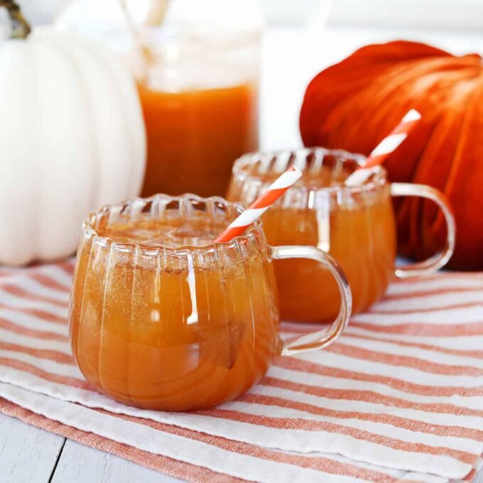 Sip the Magic: Crafting Authentic Harry Potter Pumpkin Juice at Home 6 A glass of homemade Harry Potter Pumpkin Juice, garnished with a pumpkin-shaped glass and an orange striped straw.