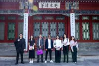 Groupe de doctorants marocains souriants en formation technologique en Chine, avec des représentants de Huawei et du Ministère de l'Enseignement Supérieur en arrière-plan.