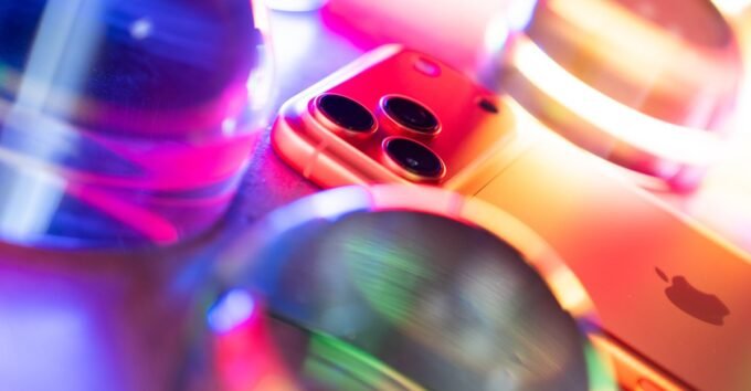 Close-up of a modern smartphone, possibly an iPhone, with a subtle background showing circuit board elements or memory chips, symbolizing the rising cost of components.