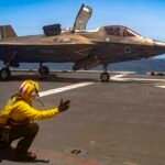 An F-35B Lighting II jet taking off from the flight deck of the America-class amphibious assault ship USS Tripoli.