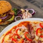 Une table de repas au Maroc, présentant un mélange de plats traditionnels riches en légumes et fruits, et d'aliments modernes plus gras et sucrés, illustrant la transition nutritionnelle.