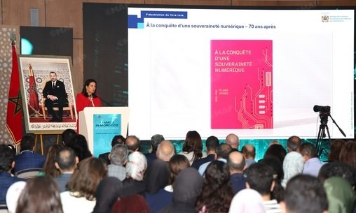 Ministre déléguée Amal El Fallah Seghrouchni présentant la feuille de route Maroc IA 2030 à Rabat, avec des écrans affichant des graphiques et des participants attentifs.
