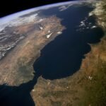 Vue aérienne du détroit de Gibraltar, séparant l'Europe de l'Afrique, avec les côtes clairement visibles sous un ciel dégagé. La photographie, prise par la NASA, met en évidence l'importance stratégique de cette voie maritime.