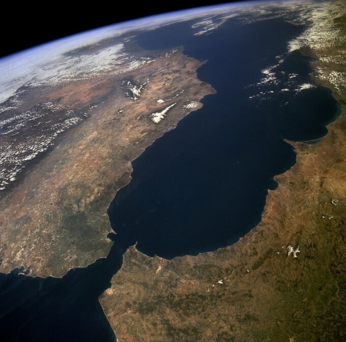 Vue aérienne du détroit de Gibraltar, séparant l'Europe de l'Afrique, avec les côtes clairement visibles sous un ciel dégagé. La photographie, prise par la NASA, met en évidence l'importance stratégique de cette voie maritime.