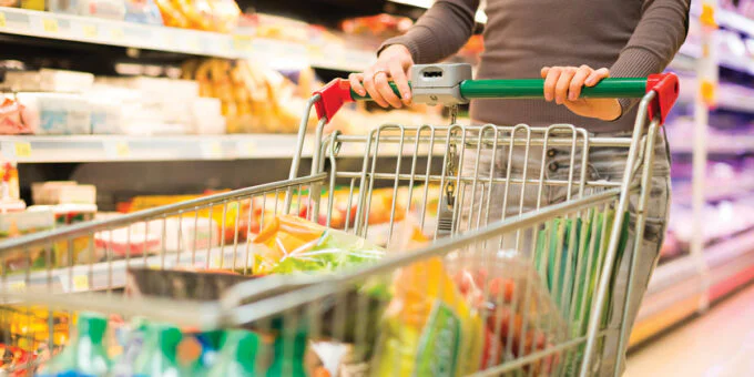 Un étal de marché marocain coloré présentant une variété de produits locaux et internationaux, symbolisant la préférence des consommateurs pour les marques nationales.