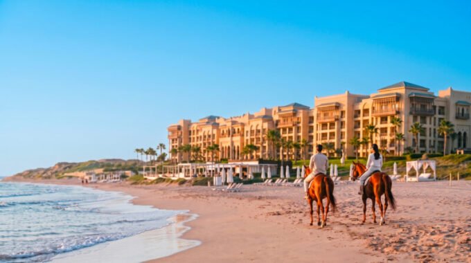 Vue panoramique du Mazagan Beach & Golf Resort au coucher du soleil, avec la plage et le parcours de golf en arrière-plan, illustrant une évasion luxueuse et relaxante.