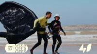 Vue aérienne de la médina d'Essaouira et de sa plage, avec des festivaliers profitant de la musique électronique en plein air, symbolisant les 10 ans du MOGA Festival.
