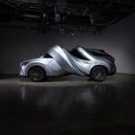 Surreal automotive sculptures by MSCHF, a Lexus RZ 450e twisted into a circle and an RX 450h+ spiraled, displayed at MOTOMORPHOSIS exhibition.