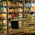 Un consommateur examine attentivement les prix dans un rayon de supermarché, symbolisant la pression sur le pouvoir d'achat en France.