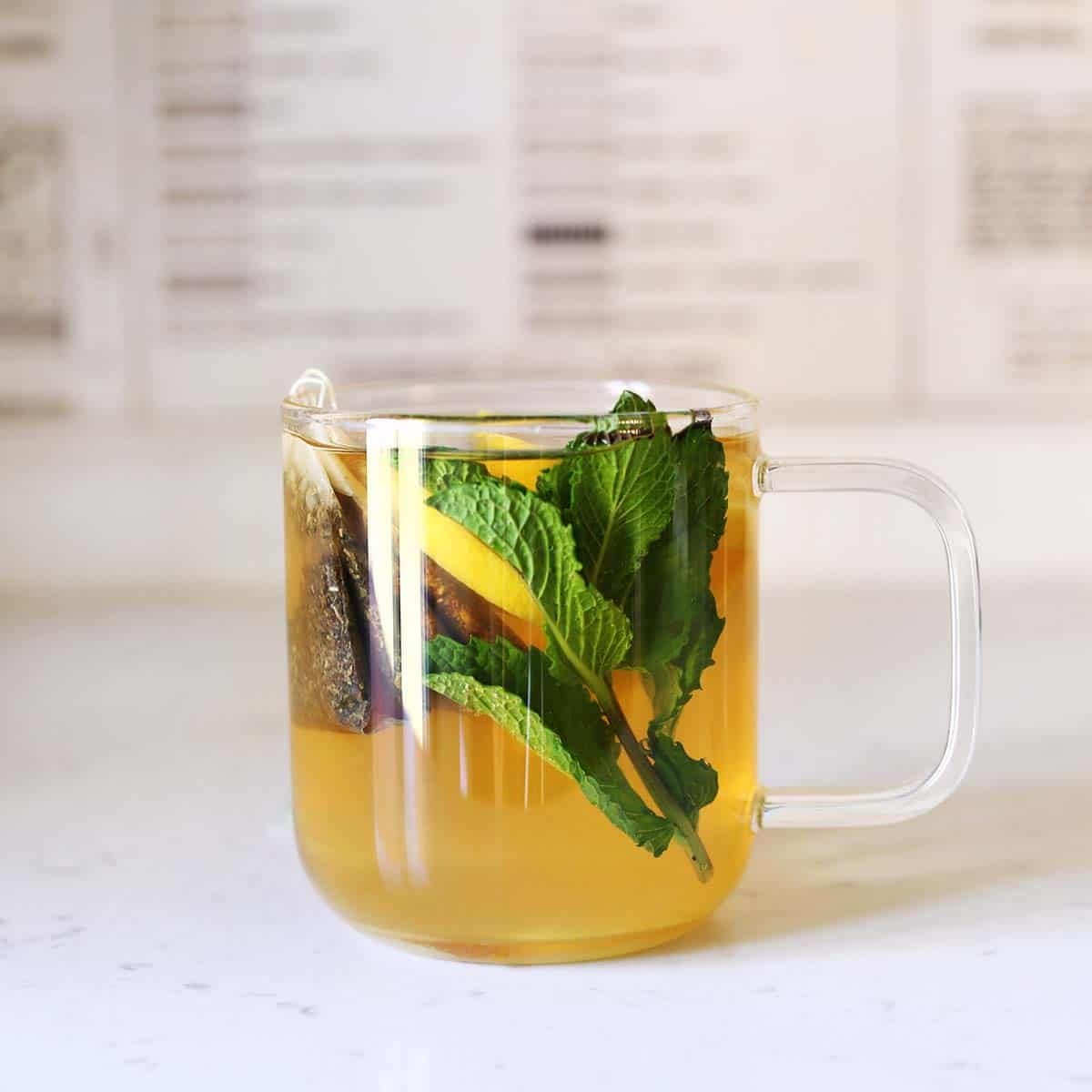 A warm mug of Starbucks Medicine Ball tea with lemon slices and mint leaves