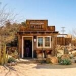 A stunning desert landscape at sunset, featuring a unique hotel blending into the environment.