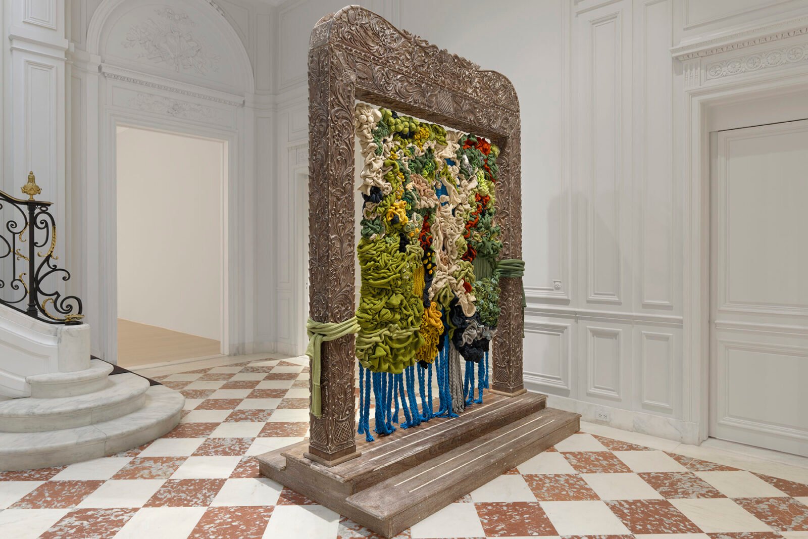 Wangari Mathenge's 'Re-membering XIII (May the Wind Be Always at Your Back)' showing figures in a richly layered domestic interior.