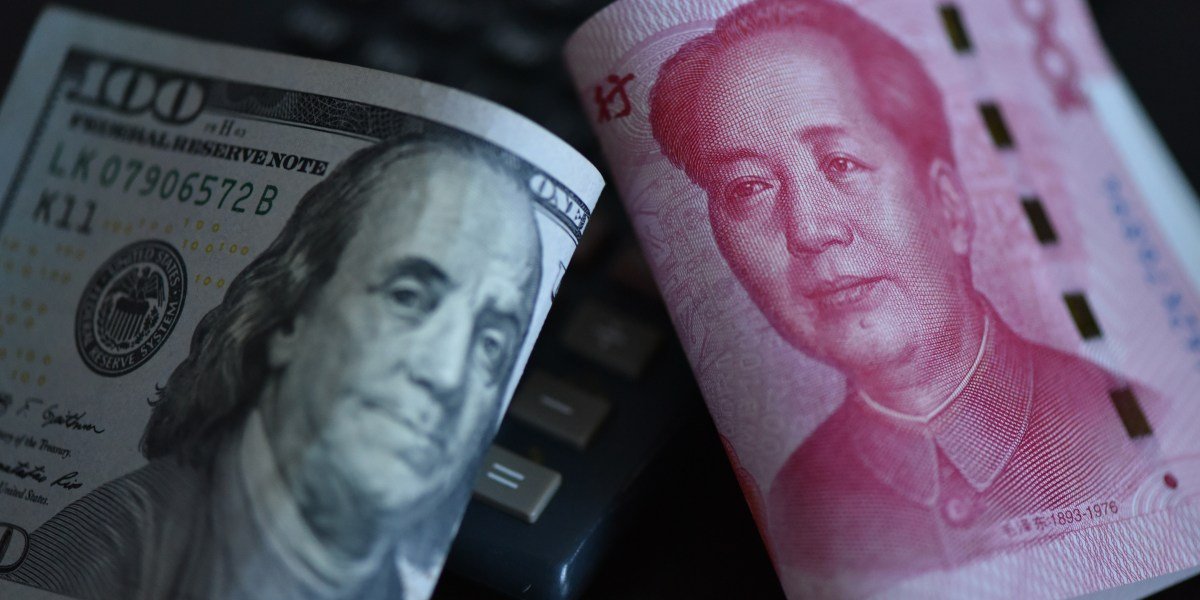 Chinese Yuan banknotes alongside US Dollar bills, symbolizing the global currency landscape.