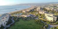 Une scène d'humoristes sur scène avec un public riant, symbolisant le festival Comediablanca à Taghazout Bay.