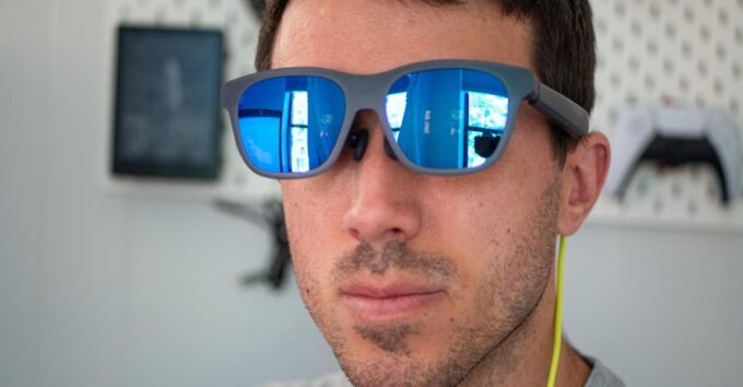 A person wearing sleek Xreal video glasses, immersed in a vibrant 3D movie experience.
