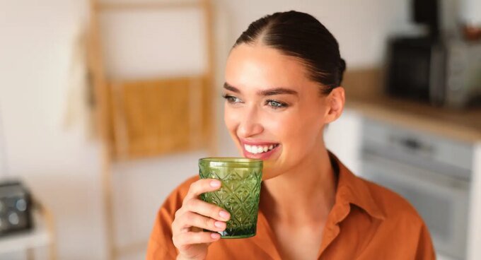 Variété de boissons chaudes et rafraîchissantes (thé matcha, thé noir, chicorée, cacao, eau citronnée) disposées sur une table en bois au lever du soleil, symbolisant des alternatives énergisantes au café.