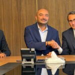Vue aérienne d'une zone logistique moderne avec des entrepôts et des camions, symbolisant l'investissement de La Voie Express Group à Lqliâa.