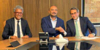Vue aérienne d'une zone logistique moderne avec des entrepôts et des camions, symbolisant l'investissement de La Voie Express Group à Lqliâa.