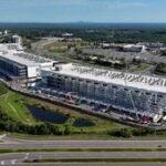 The AI Data Center Boom: A Looming Economic Reckoning? 8 Construction workers building a large data center campus with cranes and heavy machinery, symbolizing the AI infrastructure boom.