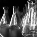 Robots performing lab tasks in a modern wet lab, symbolizing AI-driven drug discovery automation.