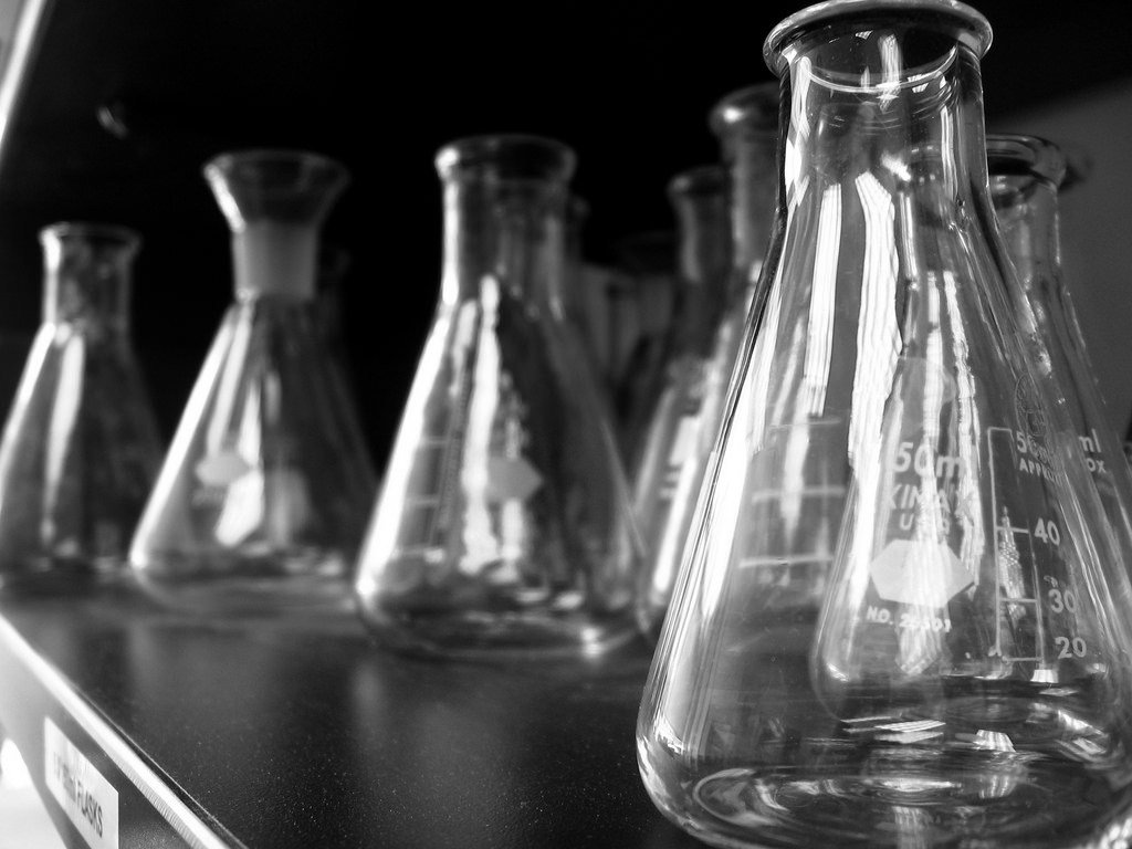 Robots performing lab tasks in a modern wet lab, symbolizing AI-driven drug discovery automation.