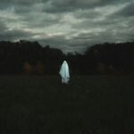 Eerie, atmospheric image of a haunted location in the United States, perhaps a historic mansion or an old lighthouse at dusk.