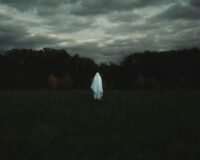 Eerie, atmospheric image of a haunted location in the United States, perhaps a historic mansion or an old lighthouse at dusk.