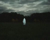 Eerie, atmospheric image of a haunted location in the United States, perhaps a historic mansion or an old lighthouse at dusk.