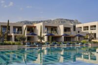 Exterior view of Amoh Resort in Rhodes, showcasing its low-rise stone architecture blending seamlessly with the coastal landscape.