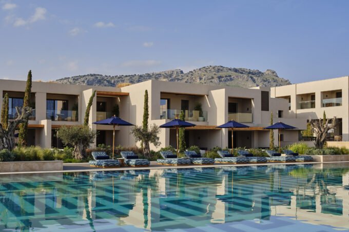 Exterior view of Amoh Resort in Rhodes, showcasing its low-rise stone architecture blending seamlessly with the coastal landscape.