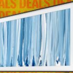 A Samsung Frame TV displaying artwork in a modern living room setting.