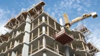 Vue panoramique de Casablanca avec des immeubles résidentiels et des grues de construction, symbolisant la croissance urbaine et la crise du logement.