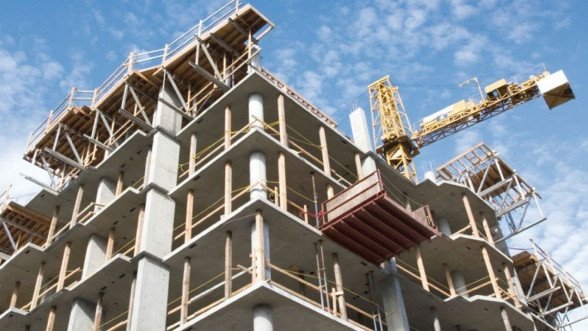 Vue panoramique de Casablanca avec des immeubles résidentiels et des grues de construction, symbolisant la croissance urbaine et la crise du logement.