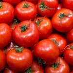Casablanca : tomates et bovin augmentent, avocat, agrumes et ovin reculent 6 Un étal de marché de gros débordant de légumes et de fruits frais, avec des caisses de tomates et d'agrumes, symbolisant la fluctuation des prix à Casablanca.