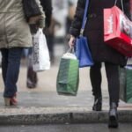 Une famille faisant ses courses, le visage préoccupé devant les étiquettes de prix, illustrant la complexité du pouvoir d'achat malgré la hausse de la consommation.
