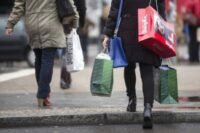 Une famille faisant ses courses, le visage préoccupé devant les étiquettes de prix, illustrant la complexité du pouvoir d'achat malgré la hausse de la consommation.