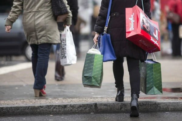 Une famille faisant ses courses, le visage préoccupé devant les étiquettes de prix, illustrant la complexité du pouvoir d'achat malgré la hausse de la consommation.