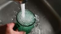 A sleek countertop water filter next to a kitchen sink, providing clean drinking water.
