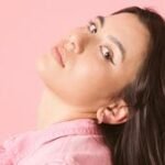 Ayano Swisher working on ceramics in her studio, surrounded by collage and printmaking art, representing 'Sad Girl Lab'.