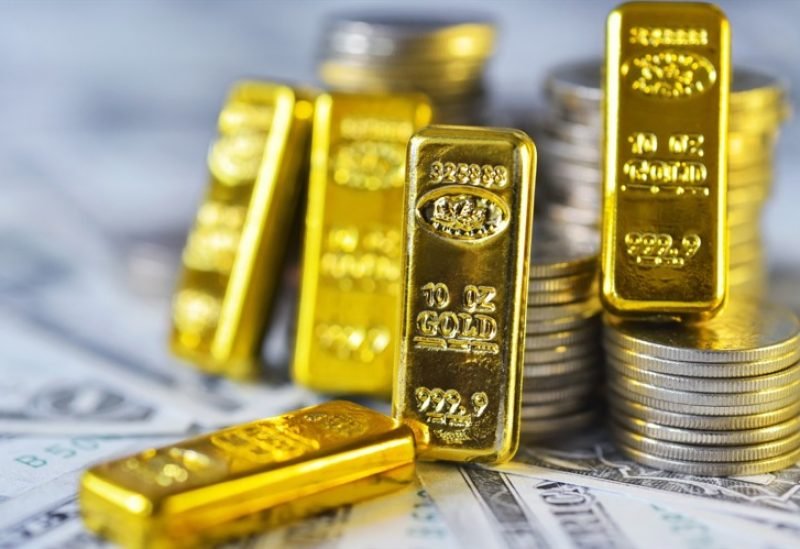 صورة لسبائك ذهبية متلألئة مع رسوم بيانية اقتصادية في الخلفية، ترمز لارتفاع أسعار الذهب وتأثرها بالسياسات النقدية.