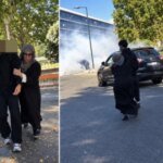 صورة لأم تسحب ابنها المراهق من أمام ثانوية فرنسية تشهد احتجاجات طلابية، مع دخان يتصاعد في الخلفية.