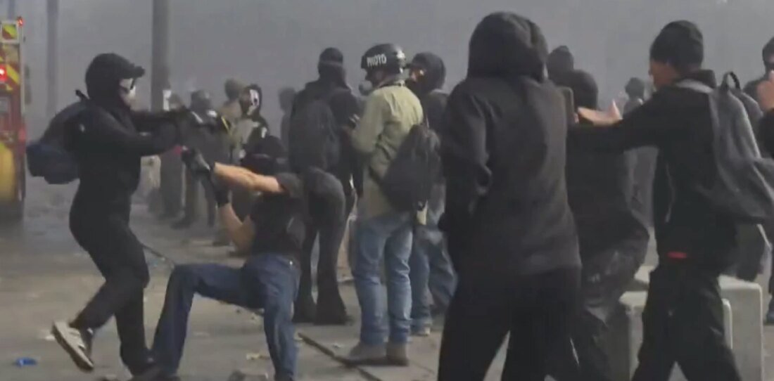 صورة لمظاهرات ليلية في إحدى المدن الفرنسية تظهر حشوداً ودخاناً في الخلفية، مع وجود قوات الأمن.