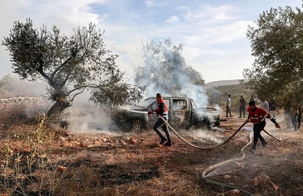 صورة تظهر مزارعين فلسطينيين يقطفون الزيتون في الضفة الغربية تحت تهديد المستوطنين