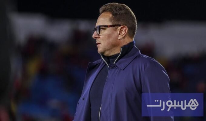 صورة لشعار نادي الزمالك مع خلفية لملعب كرة قدم، تعكس أخبار النادي الرياضية.