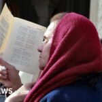 امرأة مسيحية تصلي في كنيسة المعمودية بالأردن، موقع المغطس، خلال قداس حج كاثوليكي.