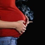 صورة تعبيرية لأم حامل وطفل رضيع، ترمز لتأثير النيكوتين على صحة الطفل