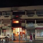 صورة تظهر آثار الحريق المدمر في سوق التقدم (أوبيهي) بمدينة تزنيت، مع وجود فرق الإطفاء