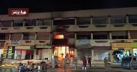 صورة تظهر آثار الحريق المدمر في سوق التقدم (أوبيهي) بمدينة تزنيت، مع وجود فرق الإطفاء