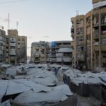 خيام تؤوي نازحين فلسطينيين وسط مبانٍ متضررة في مدينة غزة